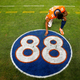Courtland Sutton #14 of the Denver Broncos kneels and takes a moment in front of the #88 tribute logo to the late former Denver Broncos player Demaryius Thomas after the game against the Detroit Lions at Empower Field At Mile High on December 12, 2021 in Denver, Colorado.